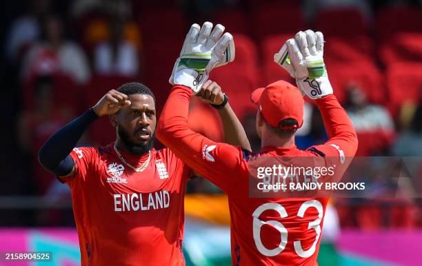 England's Chris Jordan celebrates with captain Jos Buttler the dismissal of India's Hardik Pandya during the ICC men's Twenty20 World Cup 2024...