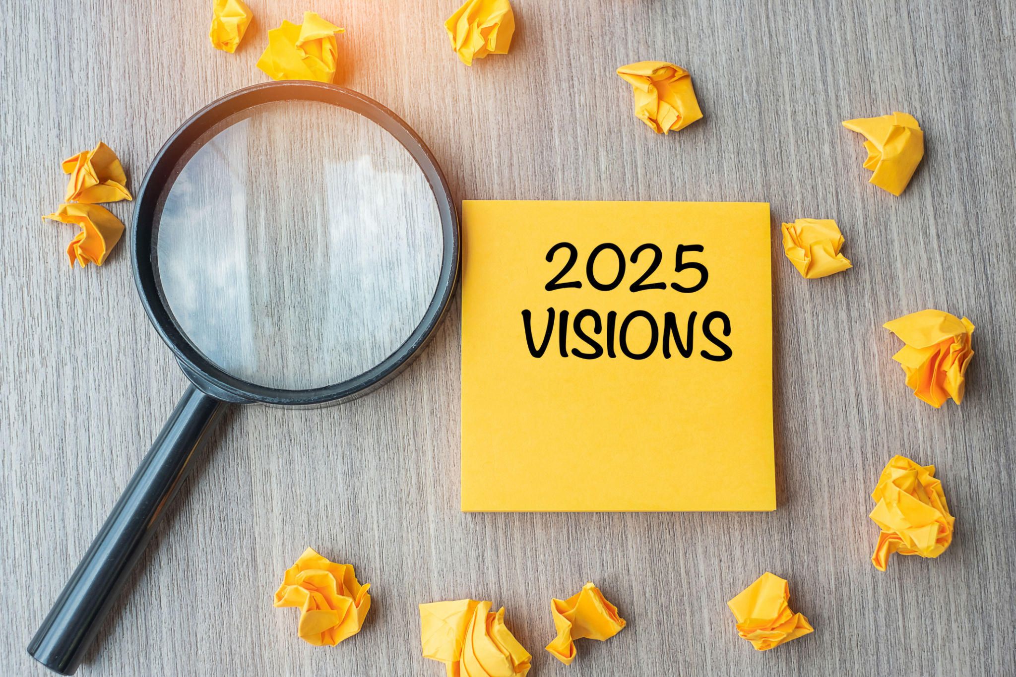 2025 VISIONS words on yellow note with crumbled paper and magnifying glass on wooden table background. New Year New Start, Idea, Strategy, and Goals concept 2025 VISIONS words on yellow note with crumbled paper and magnifying glass on wooden table background. New Year New Start, Idea, Strategy, and Goals concept