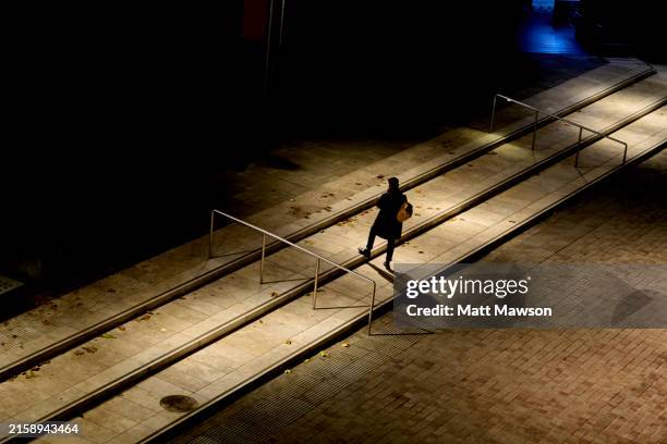 a lone man standing on an empty street at night lluminated by a bright street light south east london england uk - atmospheric mood stock pictures, royalty-free photos & images