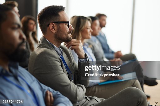 Smiling male entrepreneur with his colleagues on education event in board room. Smiling male entrepreneur with his colleagues on education event in board room.