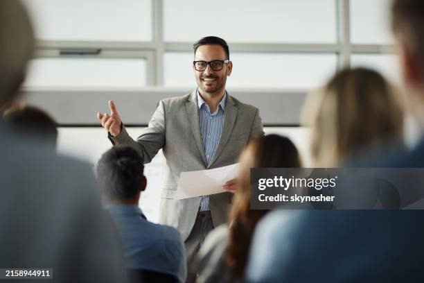 heureux homme d’affaires, prononçant un discours à ses collègues au bureau. - leader photos et images de collection