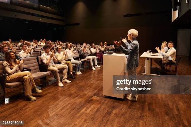 crowd of happy people applauding on a seminar in convention center. - gewinner pressebereich stock-fotos und bilder