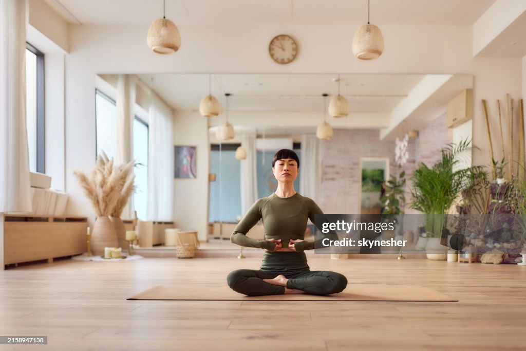 ヘルスクラブでヨガをしているリラックスした日本人女性。