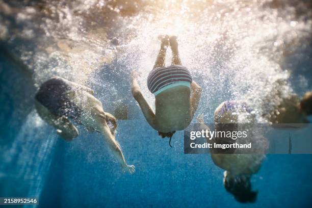 family swimming underwater in pool - backflip pool stock pictures, royalty-free photos & images
