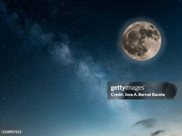 night sky with stars and the milky way with the full moon on the horizon. - mondlicht stock-fotos und bilder