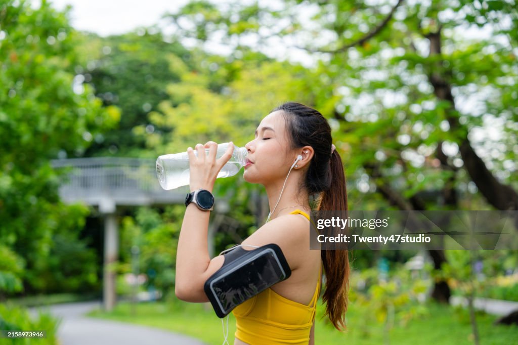 Sapping Water Asian Woman Sipping Water While Running In The Park High-Res Stock ...