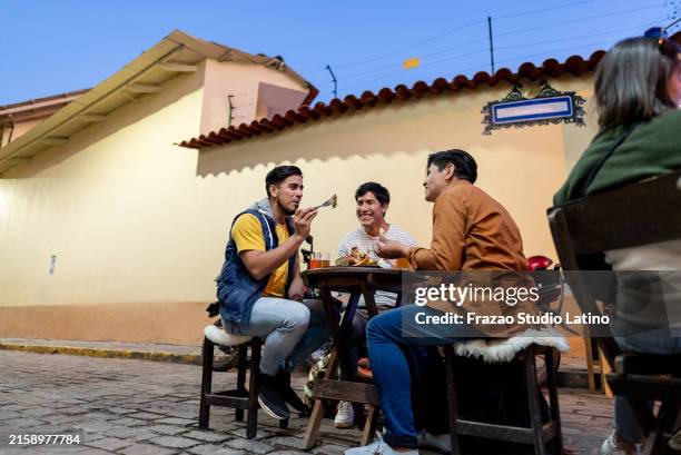 male traveler friends eating on outdoors restaurant in cusco, peru - peruvian people stock pictures, royalty-free photos & images