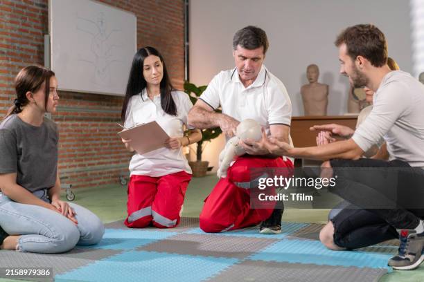 instructor teaching infant cpr to students - infant cpr stock pictures, royalty-free photos & images