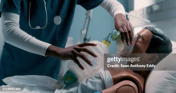 beatmungsbeutel, klinik und arzt mit dummy zum erlernen der notfallbeatmung beim arztpraktikum. gesundheits-, krankenhaus- und krankenpflegeschüler mit puppe für hlw-training mit manueller sauerstoffmaske. - kleiderpuppe stock-fotos und bilder