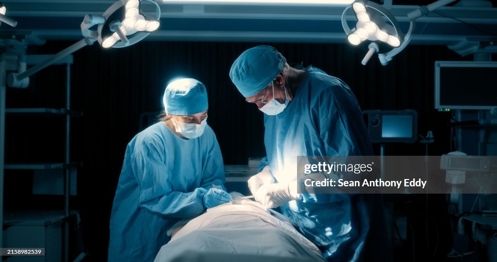Operation room, doctors and safety with night surgery, teamwork and cooperation for emergency in hospital. Group, employees and collaboration in surgical room, nurse and medicare clinic with trust