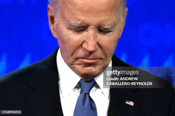 President Joe Biden looks down as he participates in the first presidential debate of the 2024 elections with former US President and Republican...
