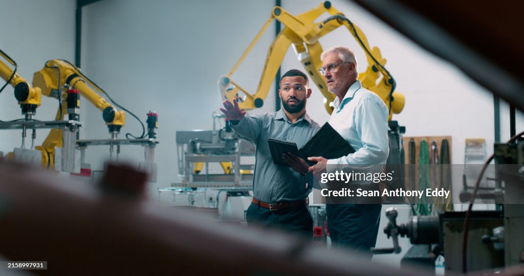 Robotics, people and engineer tablet with industrial collaboration and planning in warehouse. Factory, engineering and futuristic work of manufacturing management with discussion for cnc automation