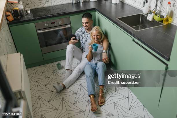 sharing a laugh over coffee on the kitchen floor - mint green stock pictures, royalty-free photos & images