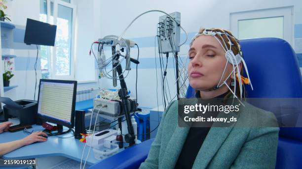 patient, der sich einem eeg-test in medizinischen einrichtungen unterzieht - eeg stock-fotos und bilder