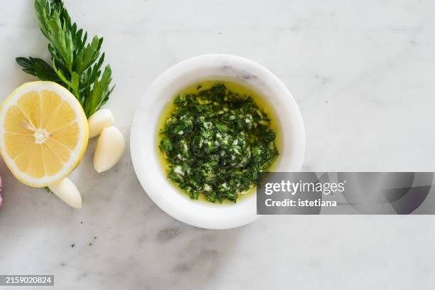 chimichurri sauce, pesto or dressing with fresh parsley, garlic, lemon, salt, and olive oil - pesto sauce stock pictures, royalty-free photos & images