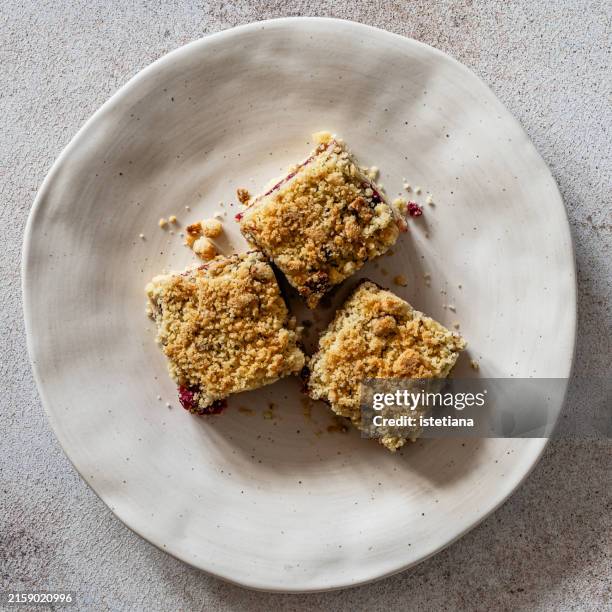 raspberry cornmeal crumble bars in rustic plate - square cake stock pictures, royalty-free photos & images