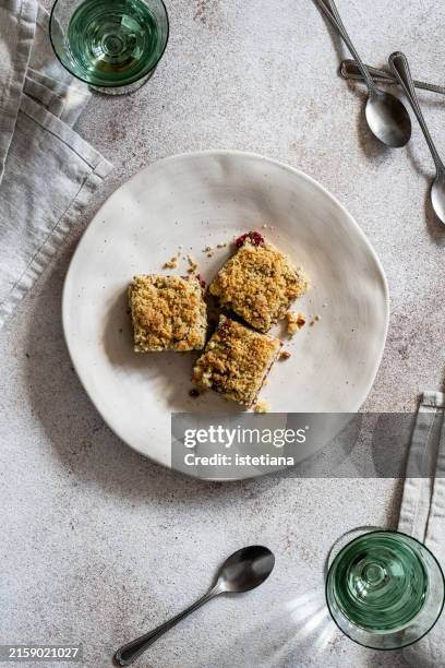 raspberry cornmeal crumble bars in rustic plate - cake crumbs stock pictures, royalty-free photos & images
