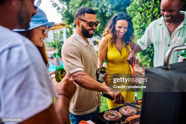 diverse group of friends and family grilling sausages, corn, and chicken skewers at a barbecue party. outdoor social gathering. summer food and cooking concept. - utegrillat bildbanksfoton och bilder