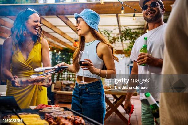 group of friends preparing food at an outdoor barbecue by the pool. social gathering with drinks and grilling. summer celebration concept. - friends picnic stock pictures, royalty-free photos & images