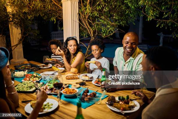 family and friends dining at an outdoor table under string lights by the pool. evening social gathering with food and drinks. summer celebration concept. medium shot. - outdoor grill stock pictures, royalty-free photos & images