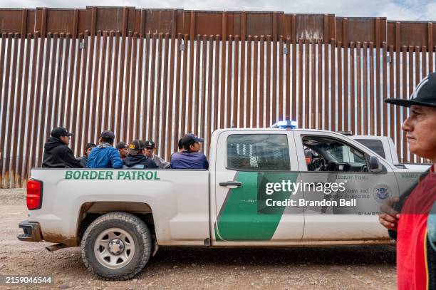 Migrants seeking asylum from Central and South America sit in the back of a border patrol vehicle after being apprehended by U.S. Customs and Border...