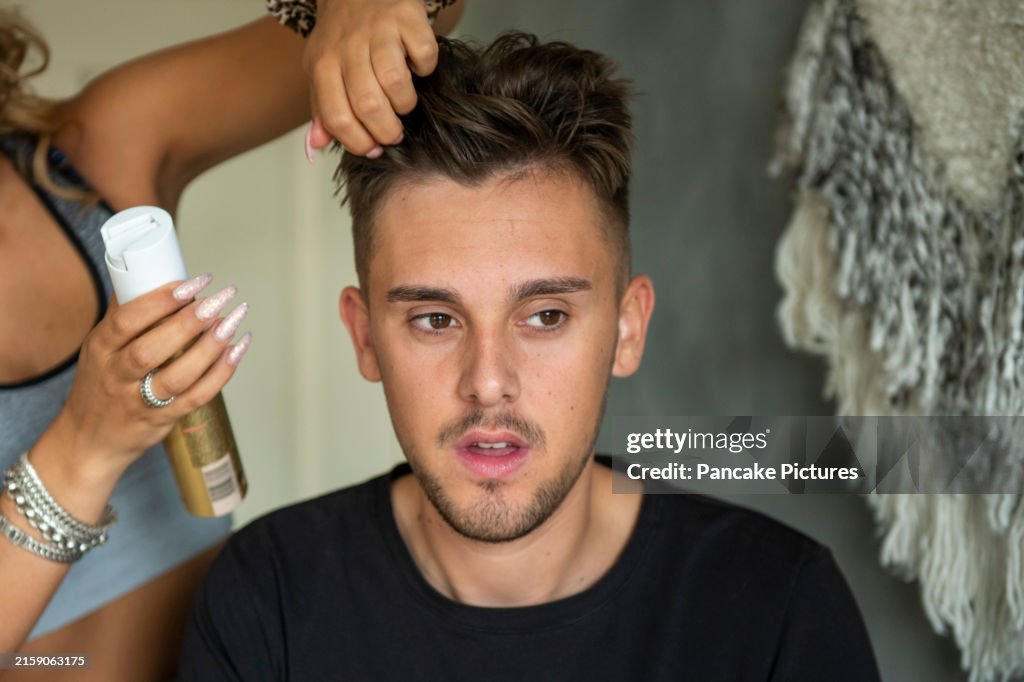 Young man getting his hair styled by a stylist
