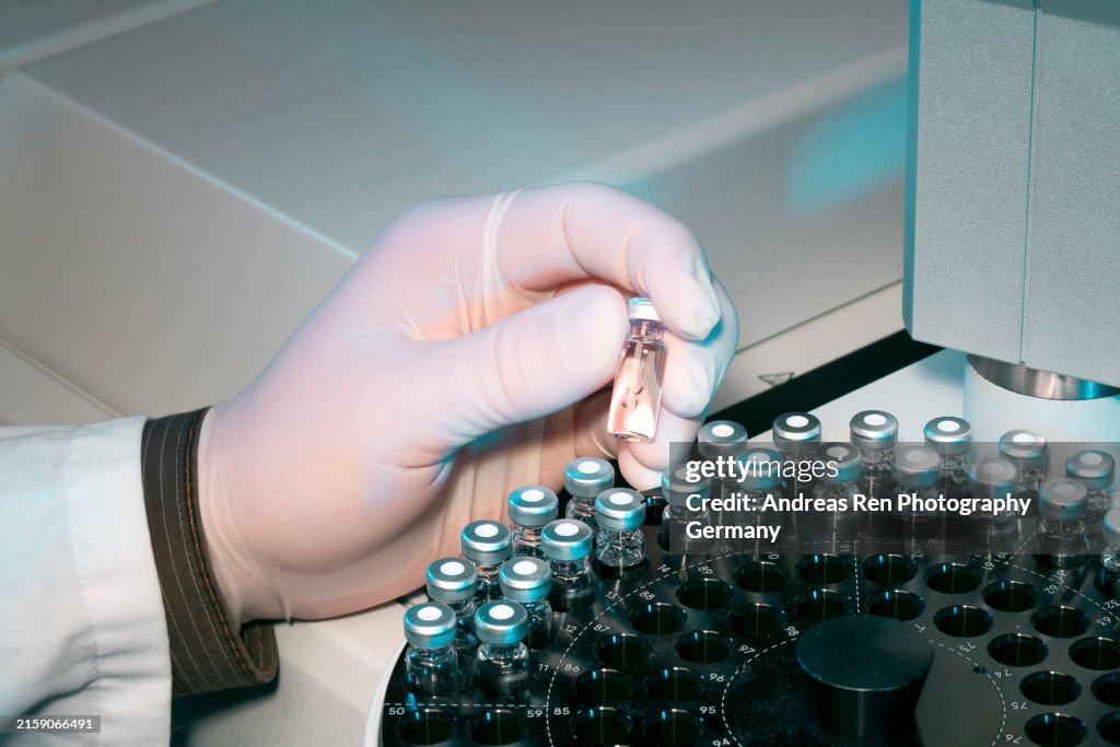 Scientist Inserting A Sample Into An Analytical Machine In A Laboratory ...