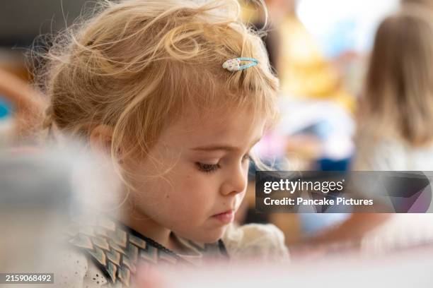 little girl focused on a creative task at playtime - hair clip stock pictures, royalty-free photos & images