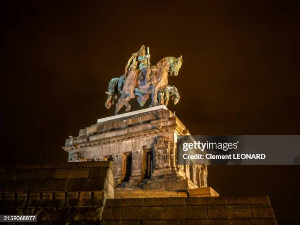 low angle side view of the equestrian statue of kaiser wilhelm i of germany at night, on the famous square of the deutsches eck, where the rivers mosel and rhine join in koblenz - rhineland-palatinate - germany. - fine art statue stock pictures, royalty-free photos & images