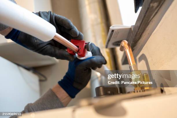 a skilled worker expertly assembles piping infrastructure - pipe cutter stock pictures, royalty-free photos & images
