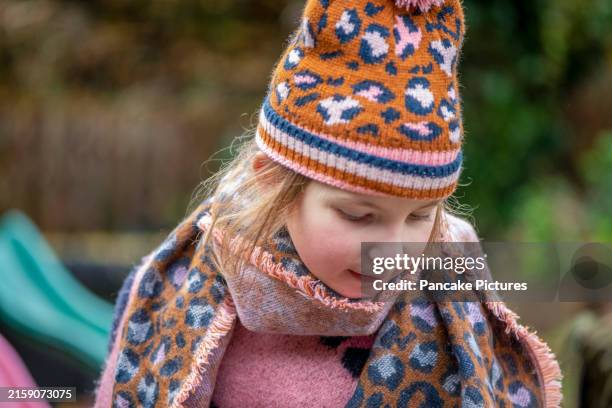 child in a patterned hat and scarf outdoors - leopard print scarf stock pictures, royalty-free photos & images