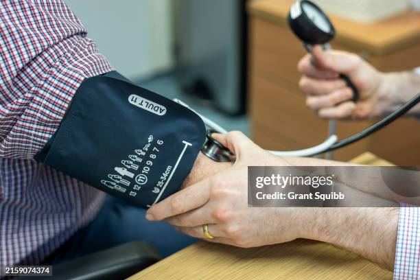 blood pressure measurement in progress - blood pressure gauge stock pictures, royalty-free photos & images