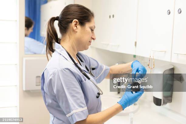 hands in gloves handling a test result - dropper bottle stock pictures, royalty-free photos & images