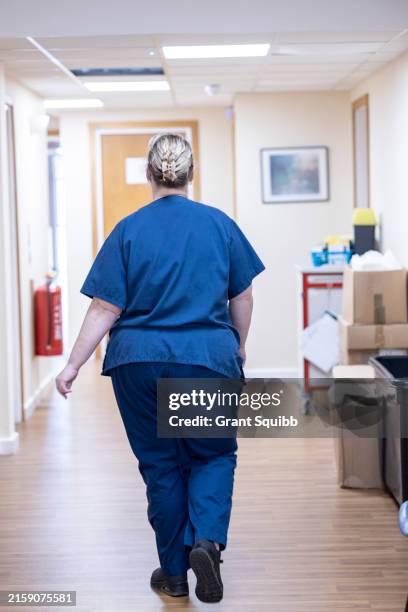 medical professional walking down a hospital corridor - corridor stock pictures, royalty-free photos & images