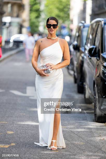 Gili Biegun wears white asymmetric dress with slit, silver bag outside Tamara Ralph during the Haute Couture Fall/Winter 2024/2025 as part of Paris...