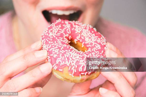 woman eating a doughnut - fried stock pictures, royalty-free photos & images