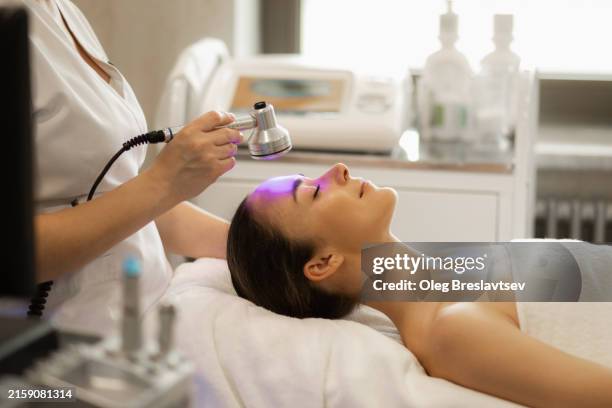 facial treatment by cosmetic medical equipment in the clinic - especialista en belleza fotografías e imágenes de stock