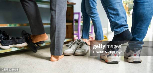 people removing their shoes at the entrance of office - uitkleden stockfoto's en -beelden