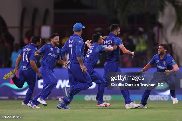 Naveen-ul-Haq of Afghanistan celebrates with teammates after dismissing Mustafizur Rahman of Bangladesh to win and to advance to the Semi Finals the...