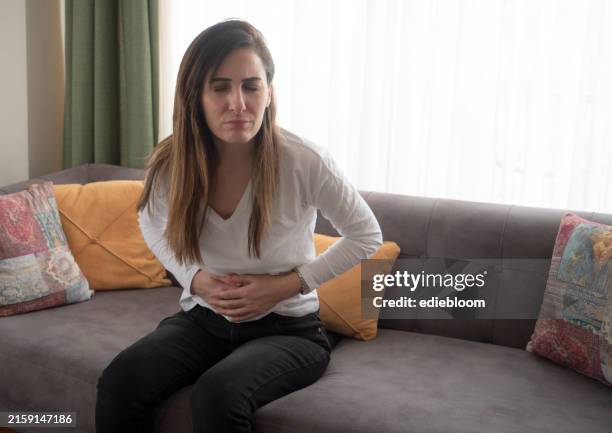 woman with menstrual pain - colorectal cancer stock pictures, royalty-free photos & images
