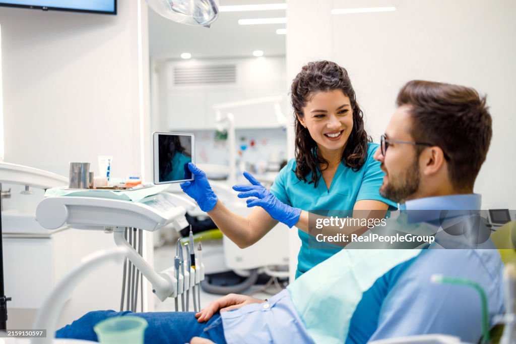 タブレットで患者の歯科情報を表示する歯科医。