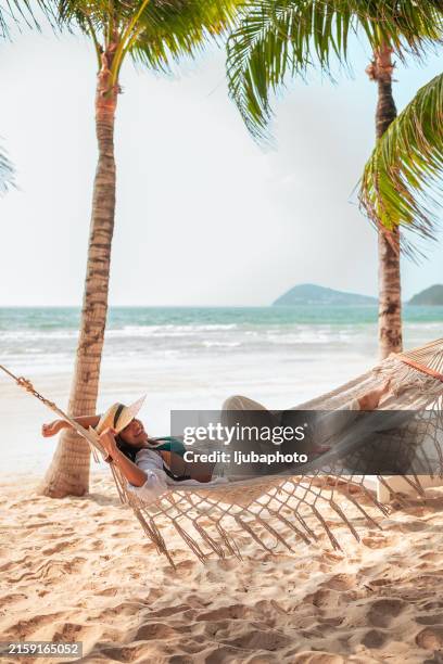 hispanic female relaxing in hammock on tropical beach - beach holiday stock pictures, royalty-free photos & images