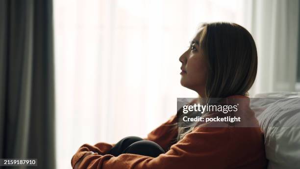 woman depression hugging herself in bedroom. - body image stock pictures, royalty-free photos & images