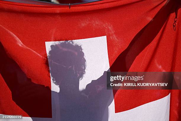 Switzerland's supporter holds the Swiss flag ahead of the UEFA Euro 2024 round of 16 football match between Switzerland and Italy at the...