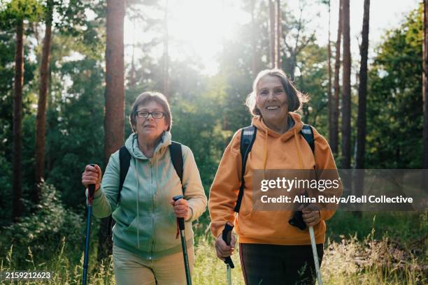 senior women on a hike - nordic walking stock pictures, royalty-free photos & images