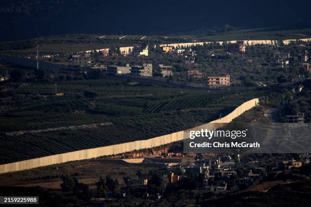 The border wall separating Israel on the left and Lebanon on the right is seen in the area of Khiam on June 25, 2024 in Khiam, Lebanon. Hezbollah and...