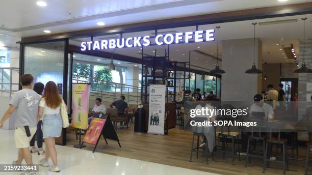 Pedestrians walk past the American multinational chain of coffeehouses Starbucks store in Hong Kong.