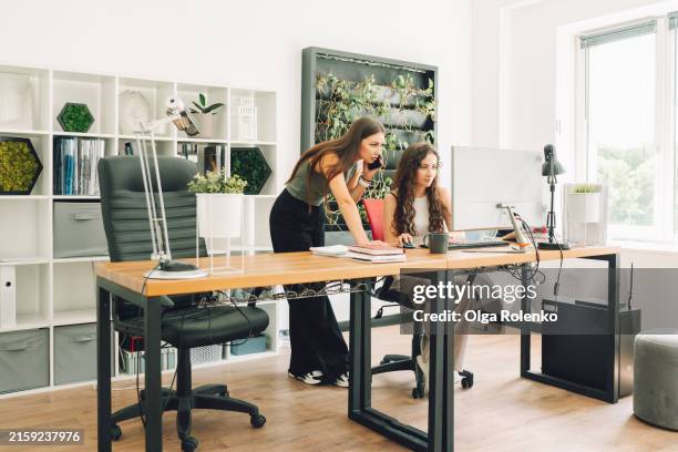 businesswomen on project: two women managers work on design project in green office. - turismo responsable fotografías e imágenes de stock