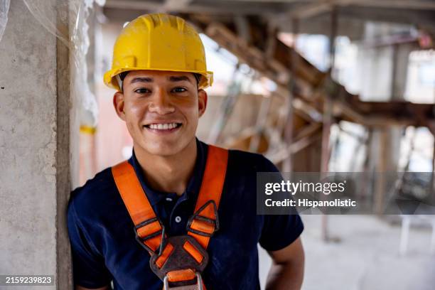 portrait of a building contractor smiling at a construction site - construction worker smiling stock pictures, royalty-free photos & images