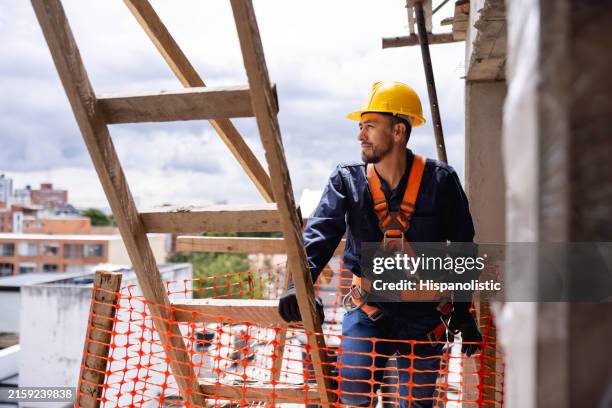 ouvrier du bâtiment travaille sur un site de construction - harnais de sécurité photos et images de collection